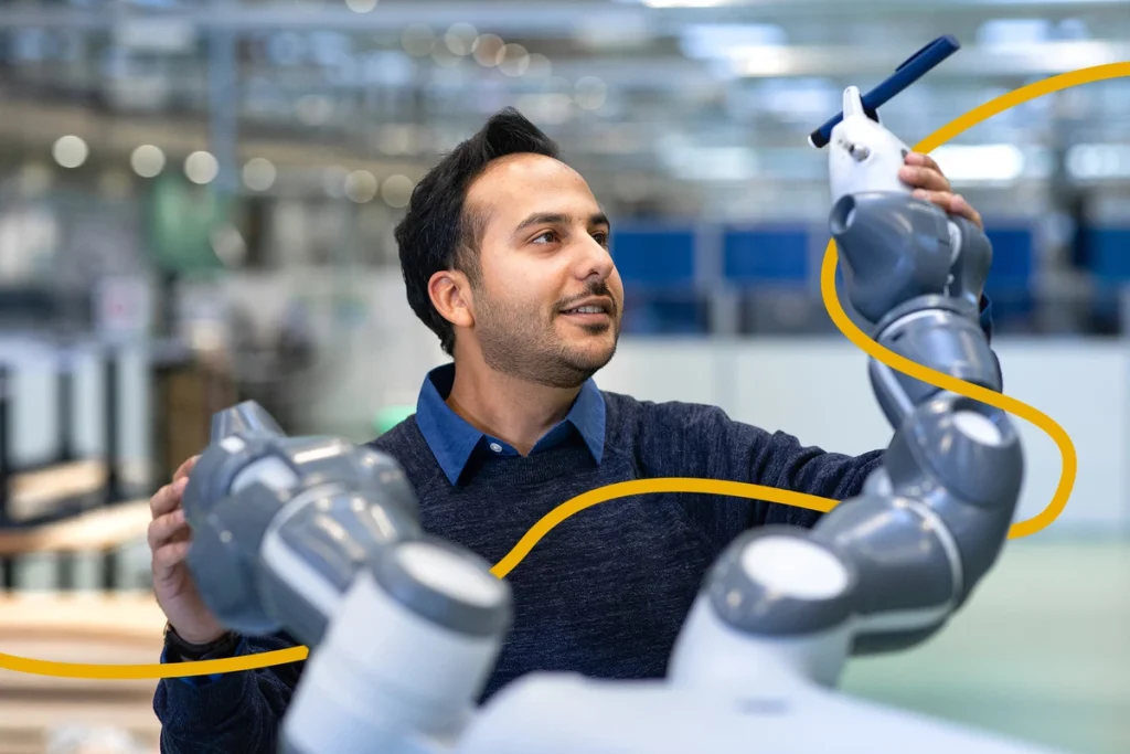 Medarbejder der arbejder med en kollaborativ robot i et laboratoriemiljø, brugt som illustration af karrieremuligheder hos Novo Nordisk.